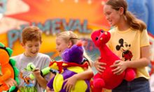 Kids having a great time with their carnival game "wins" from the Fossil Fun Games inside Disney’s Animal Kingdom.