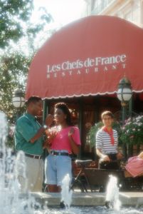 A couple standing in fromt of a restaurant at France pavillion inside EPCOT.